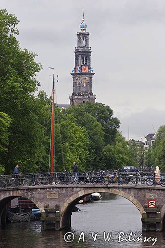 Wieża kościoła i rowery na moście nad kanałem, Amsterdam, Holandia