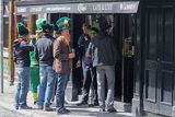 Przed pubem, mężczyźni w irlandzkich czapkach dla turystów, Dzielnica Temple Bar, Dublin, Irlandia