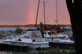 O zachodzie słońca tęcza i port na wyspie Kaunissaari koło Helsinek, Finlandia, Zatoka Fińska