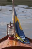 lampa naftowa i flaga szwedzka na drewnianej łódce, zlot oldtimerów w Vastervik, Szkiery Szwedzkie, Szwecja