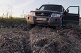 samochód terenowy zakopany w błocie, fachowa pomoc traktora niezbędna